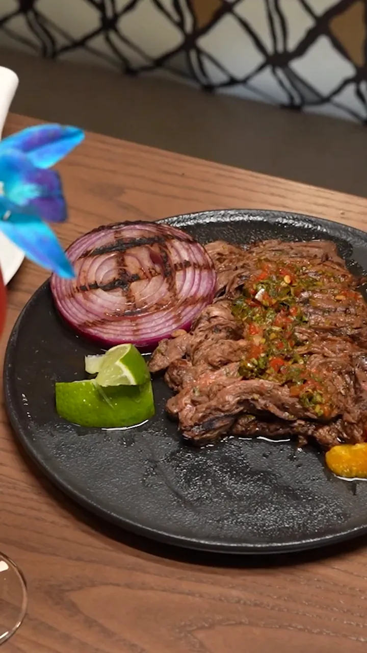 A plated skirt steak with chimichurri at Suwanee Social