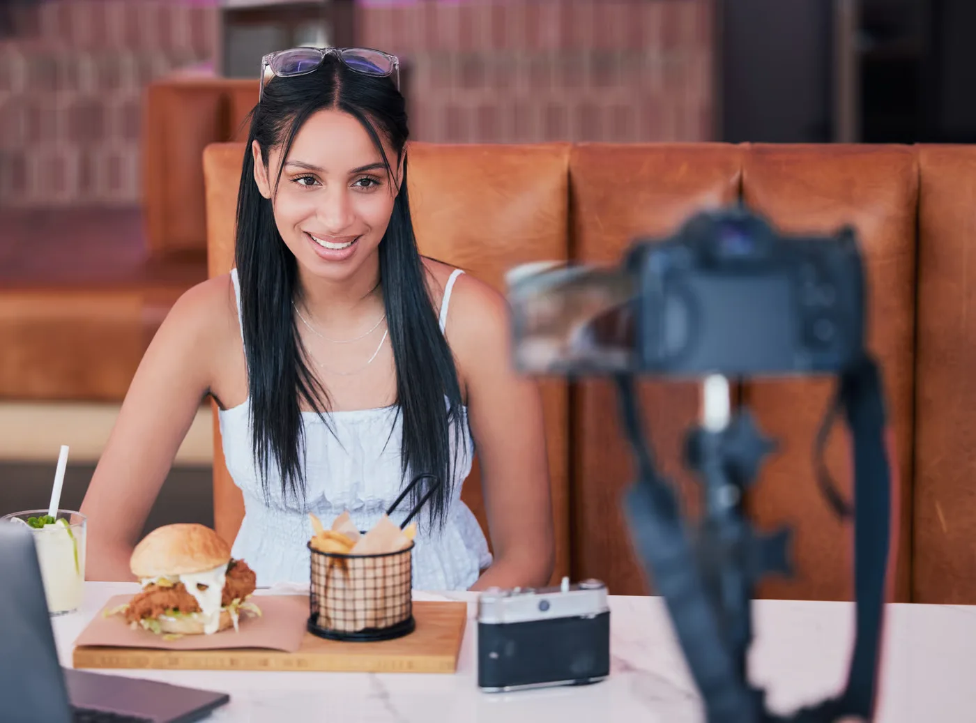 Local food creator filming a restaurant dish on a smartphone